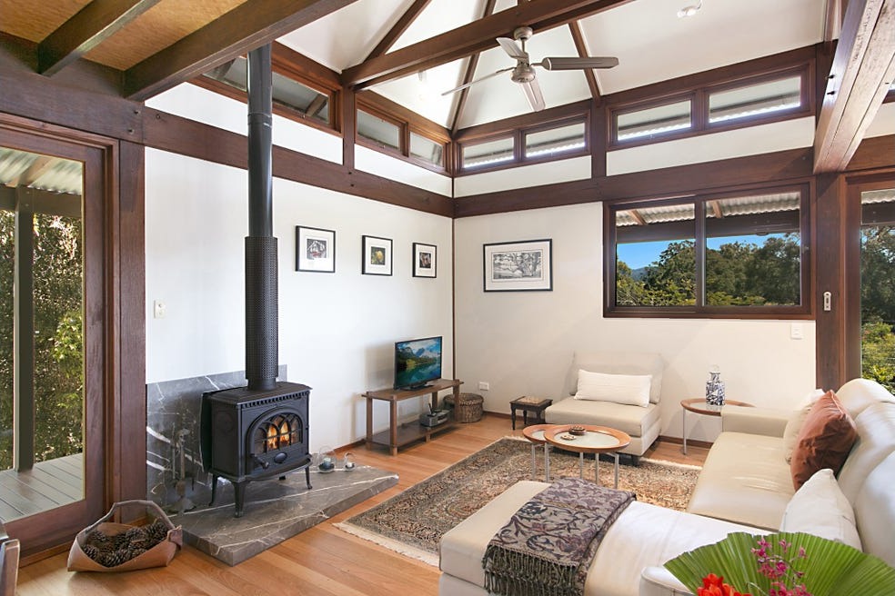 Living room with wood heater beneath timber trusses