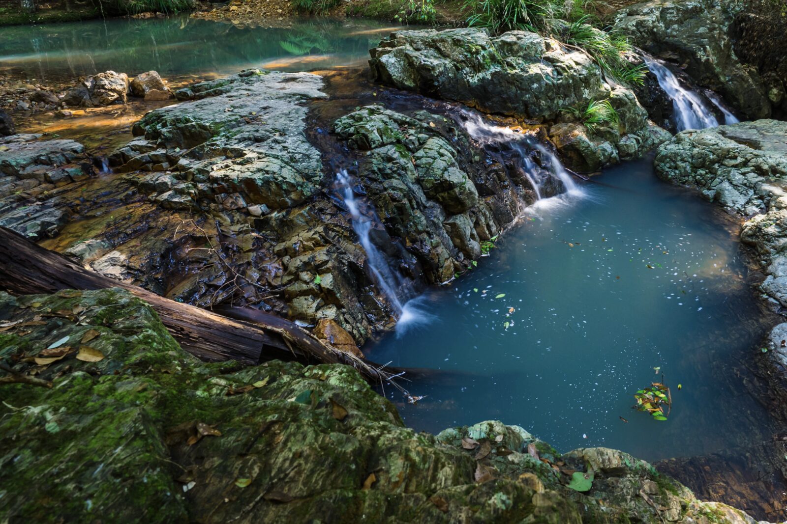 A waterfall spilling into a rock pool in the hinterland