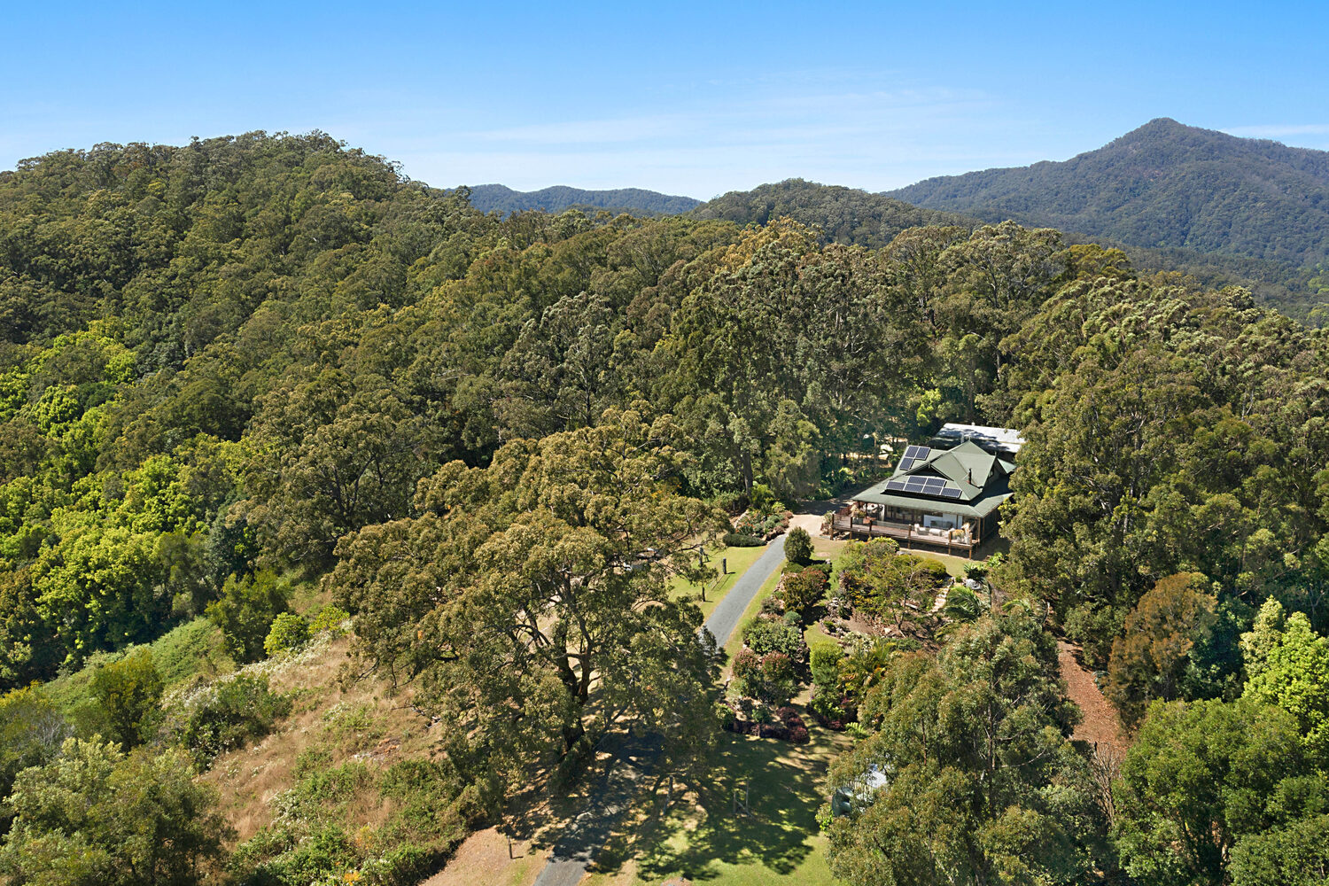 Aerial view of the Serra Luma residence set into the forested ridgeline, with the surrounding 134-acre estate